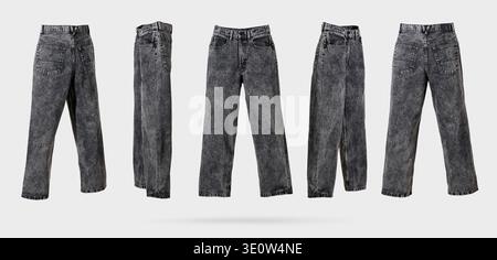 Black male acid wash denim jeans with wide leg and fading from different sides on light gray background. Concept of trendy vintage, men's street fashi Stock Photo