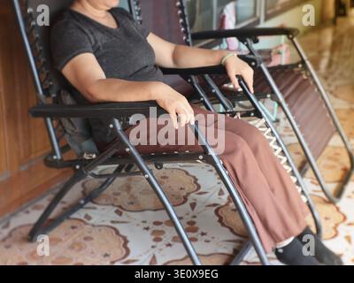 Senior woman relaxing on a reclining chair at home Stock Photo