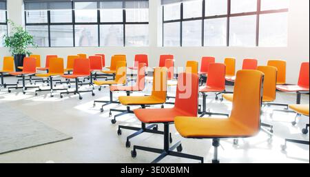 Chairs, conference or tradeshow with empty room for business convention, presentation or lecture. Interior, facility and orange seats with furniture Stock Photo