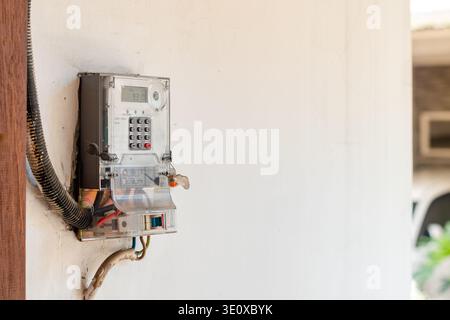 Electricity meter on the wall of the house to measure electricity consumption in the household Stock Photo