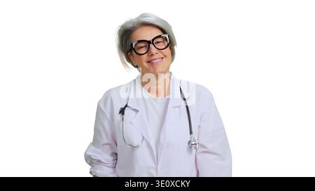 Senior female doctor wearing glasses and lab coat smiling Stock Photo