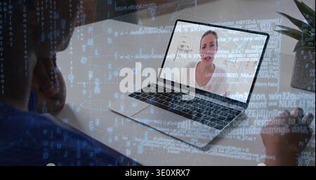 Watching woman holding mug viewing laptop at desk, with onscreen speaker in white top, code overlay Stock Photo