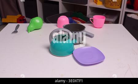 Colorful Utensils And Toys Scattered. Lively Spread Of Vibrant Kitchen Gadgets And Playthings Scattered About. An Energetic Display Of Multicolored Stock Photo