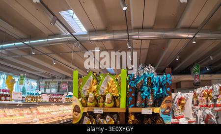 Cremona, Italy - March 7th 2026 A wide shot of a grocery store aisle in Italy featuring various brands of Easter chocolate eggs and other confectioner Stock Photo