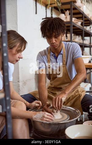 Young adults creating pottery in a calm studio environment Stock Photo