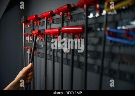 Car mechanic taking auto body repair tool off wall-mounted rack Stock Photo