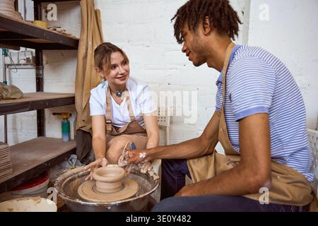 Young adults engaged in pottery making in studio Stock Photo
