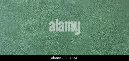 Textured green painted wall surface with thick brushstrokes and rough plaster finish Stock Photo
