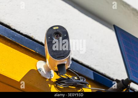 Close up view of outdoor security camera with solar panel installed on house wall. Sweden. Stock Photo