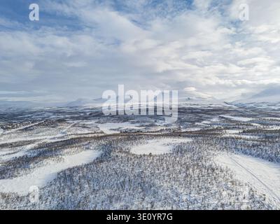 aerial panoramic view over frozen plains toward lapporten valley and arctic mountains in winter, near abisko, sweden. Stock Photo