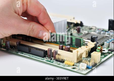 Installing a RAM module into a computer motherboard slot for upgrade or repair Stock Photo