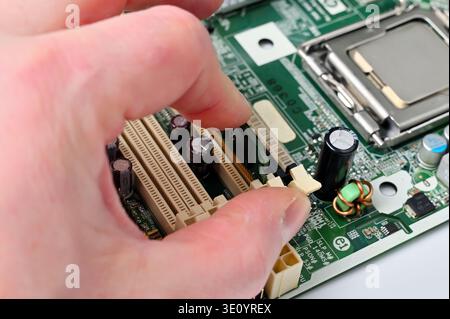 Installing a RAM module into a computer motherboard slot for upgrade or repair Stock Photo