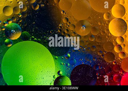 Vibrant Droplets Over Gradients. Dynamic Macro Shot Of Colorful Oil Droplets Against Vibrant Backgrounds Stock Photo