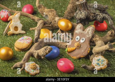 Easter cookies and colorful eggs in a natural backdrop of wood and grass Stock Photo