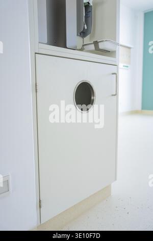 White door with round porthole-style window and a modern metal handle, new hospital in Calw, Germany Stock Photo