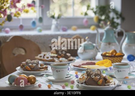 Table set with Easter cookies and coffee, decorated like spring Stock Photo