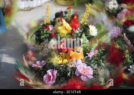 Festive Easter table centerpieces decorated with colorful chicks, feathers, flowers and speckled eggs create a whimsical spring display Stock Photo