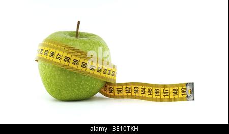 A fresh green apple is wrapped with a yellow measuring tape, symbolizing healthy eating, diet, and fitness. This image represents concepts of nutritio Stock Photo