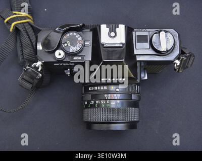 Vintage Fujica STX-1 35mm film camera laying on a table, showcasing its settings and attached lens Stock Photo