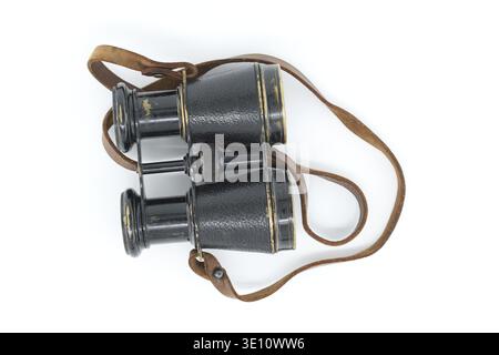 Ancient pair of black binoculars with brown leather straps isolated on white background Stock Photo