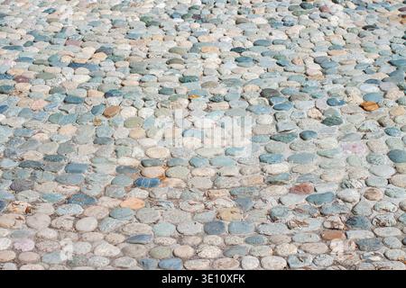 Pebble stone pavement texture background with round colorful cobblestones on walkway Stock Photo