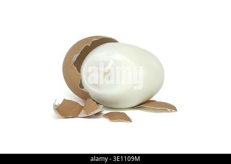 Egg in the process of being peeled, isolated on a white background, with strewn eggshell fragments surrounding it Stock Photo