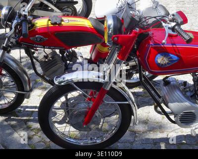 Red Famel XF-17 vintage moped with yellow stripes featuring chrome details on cobblestone street Stock Photo