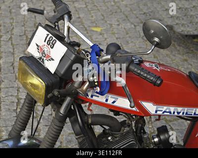 Close-up of vintage red Famel xf-17 motorcycle with number 189, parked on cobblestone street Stock Photo