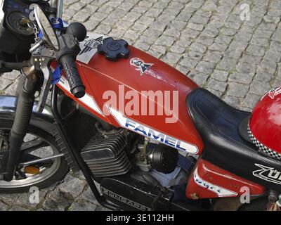 Close-up of a vintage red Famel Zuendapp motorcycle parked on a cobblestone street, showcasing its design and details Stock Photo
