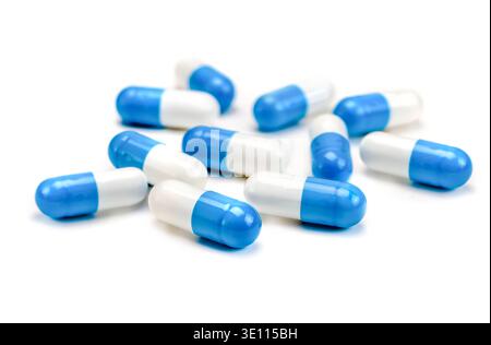 Blue white medicine capsules on white background. Close-up. Antibiotics Stock Photo