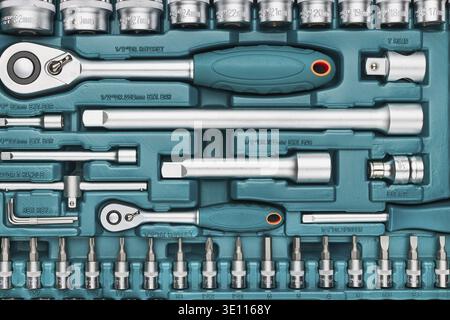 Ratchet with many attachments in plastic case. Work tools. Universal tool set. Background Stock Photo