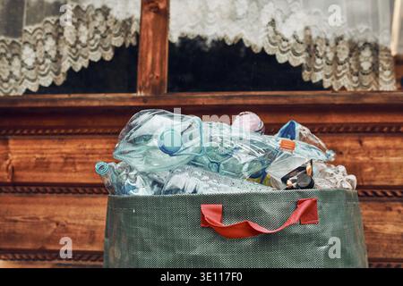 Plastic bottles collected in big container. Heap of plastic bottles, cups, bags collected to recycling. Concept of plastic pollution and too many plas Stock Photo