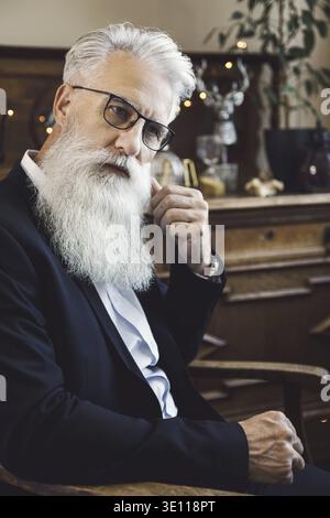 Stylish and handsome bearded senior man posing in studio Stock Photo