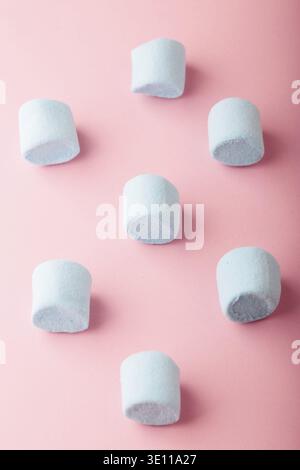 Pattern of blue marshmallows on plain pink background Stock Photo