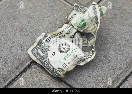 Close-up of old and crumpled one dollar bill on the ground Stock Photo