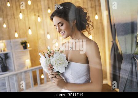 Smiling, happy and beautiful bride with bouquet of flowers Stock Photo