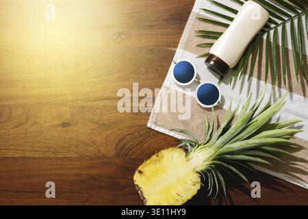 Different items for beach vacations. Sunscreen, sunglasses and pineapple fruit Stock Photo