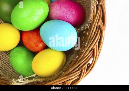 Brightly colored closeup easter eggs in basket, holiday background Stock Photo