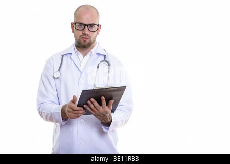 Studio shot of young bald muscular man doctor holding clipboard Stock Photo