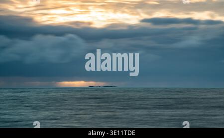 Dramatic seascape  sunset or sunrise sky with storm clouds during morning or evening. Dramatic sunset over  sea with orange black  clouds Stock Photo