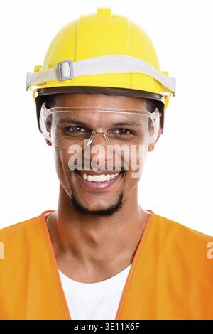 Face of happy African man construction worker smiling while wearing protective glasses Stock Photo