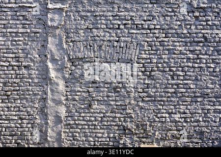Previous doorway or window opening recently blocked with matxhing brickwork and painted white - Saint-Gilles, Brussels, Belgium. Stock Photo