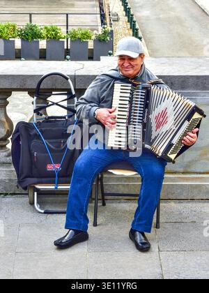 Man playing a Diamond piano accordion on the Rue Baron Horta near the Bozar gallery - Brussels, Belgium. Stock Photo