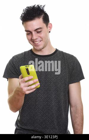 Studio shot of happy young man smiling while using mobile phone Stock Photo