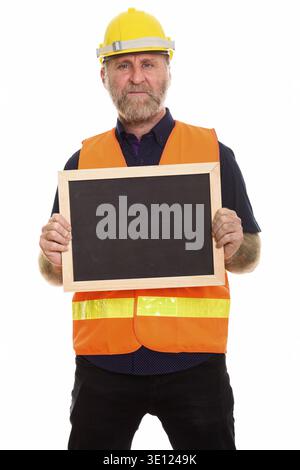 Mature bearded man construction worker holding blank blackboard Stock Photo