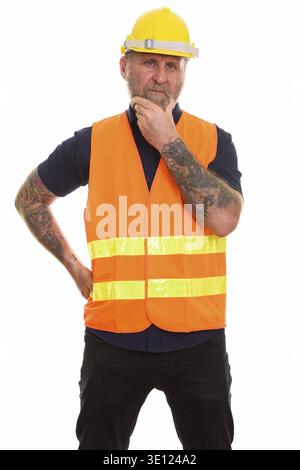 Mature bearded man construction worker with hand tattoos thinking Stock Photo