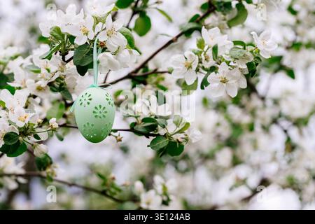 Easter green egg on a blooming apple tree. Easter greeting card. Stock Photo