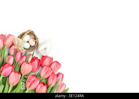 Bouquet of pink tulips, eggs in a nest and a rabbit isolated on a white background with copy space. Easter composition. View from above. Stock Photo