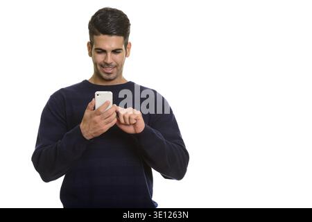 Young happy Persian man smiling and using mobile phone touching the screen Stock Photo