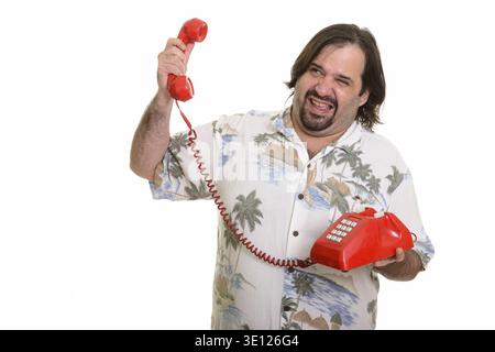 Fat Caucasian man looking stressed while holding noisy old telephone Stock Photo
